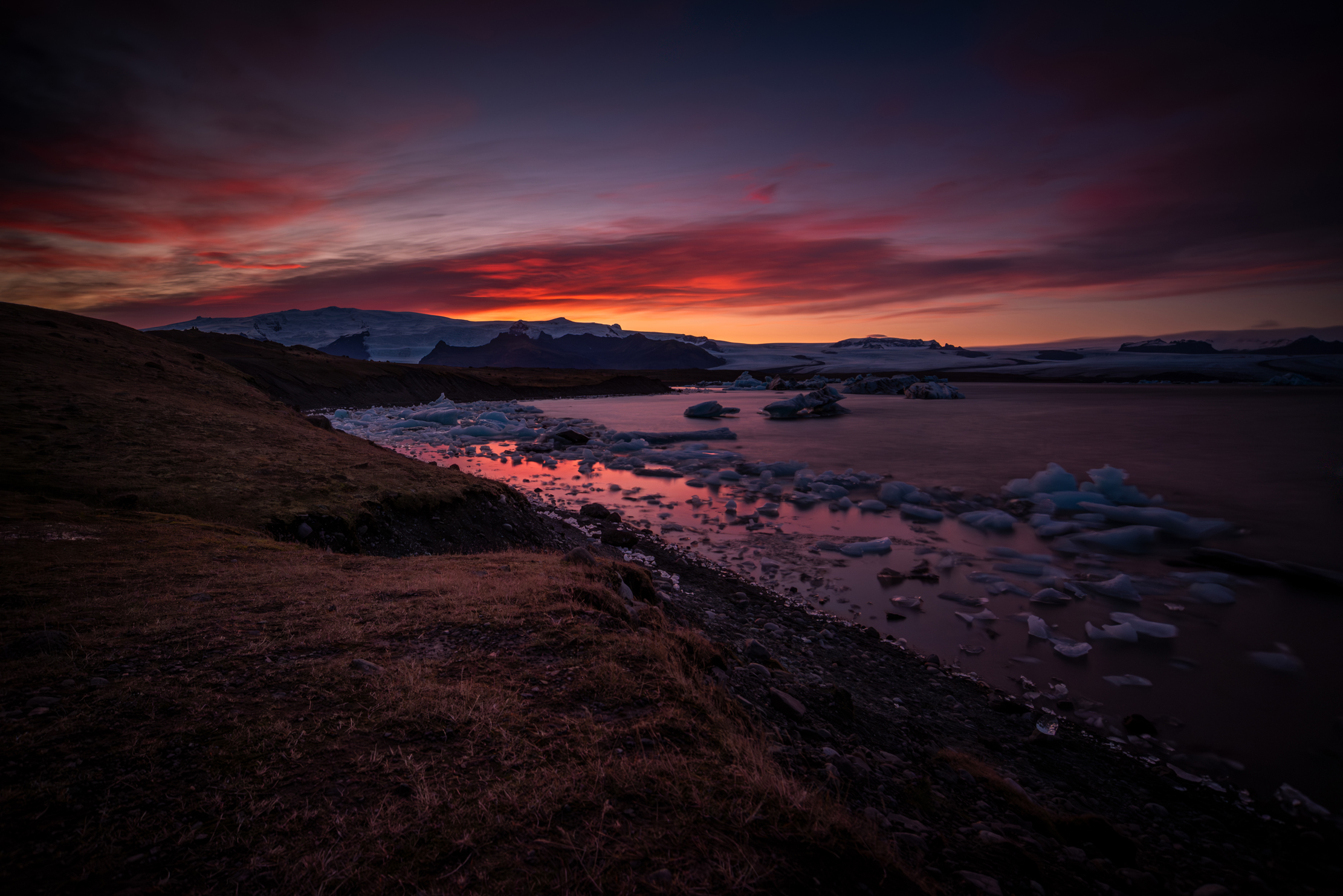 Dramatic sunset over Jökulsárlón glacier lagoon with icebergs and Vatnajökull glacier, Iceland — photographed by Marcel Strobel