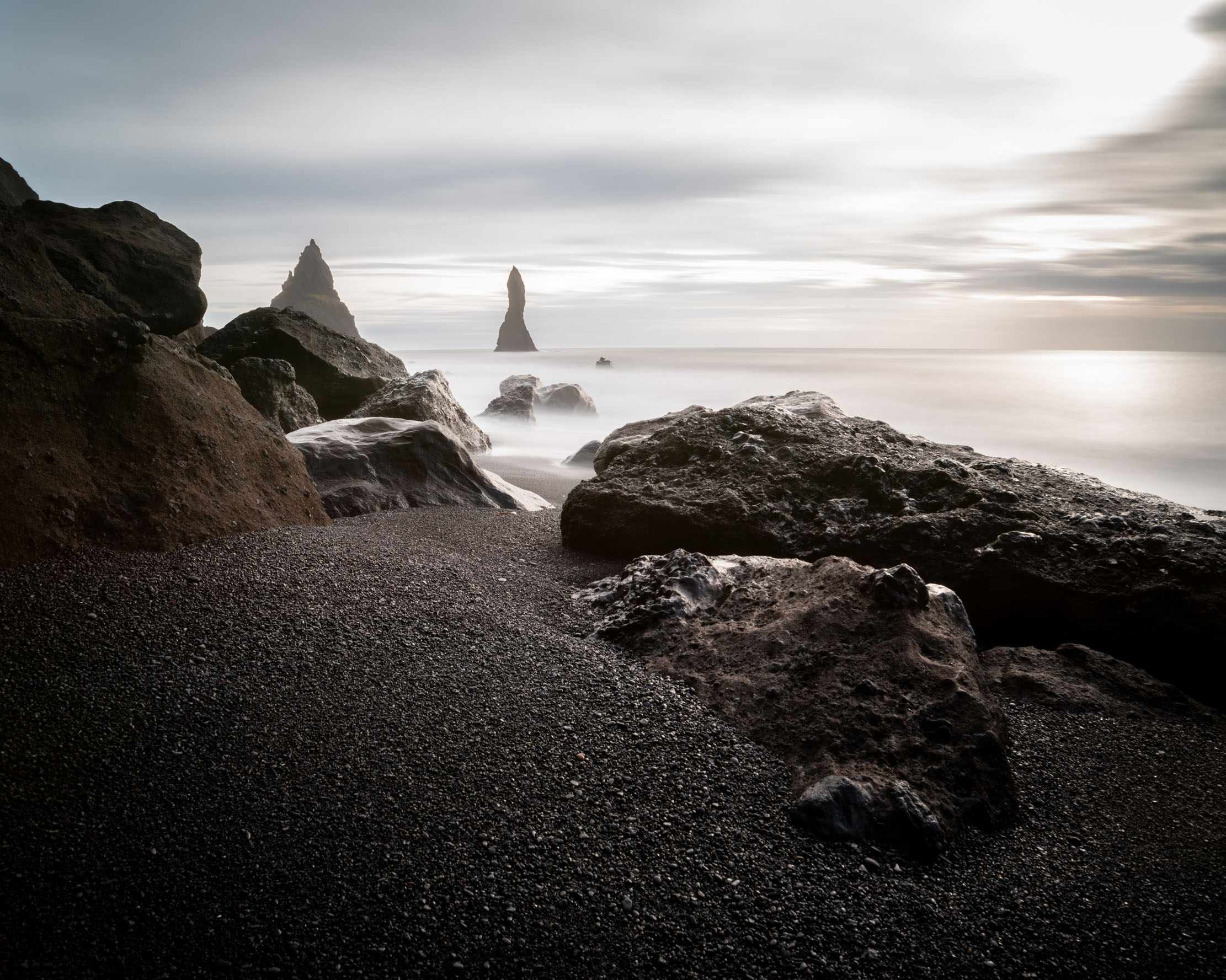 Reynisdrangar sea stacks and black volcanic sand at Reynisfjara beach, south Iceland — long exposure photography by Marcel Strobel