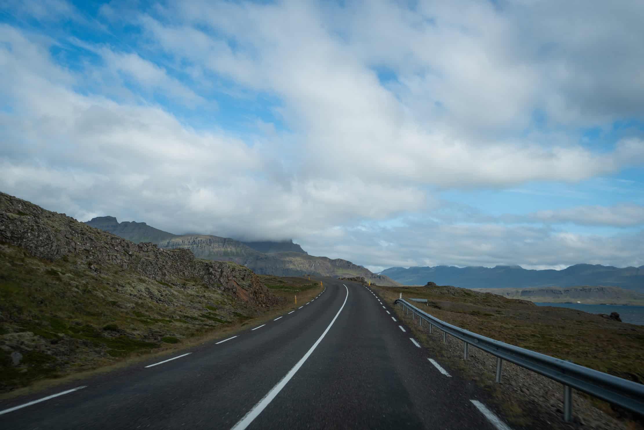 An empty coastal road winding through the mountains in East Iceland — photographed by Marcel Strobel