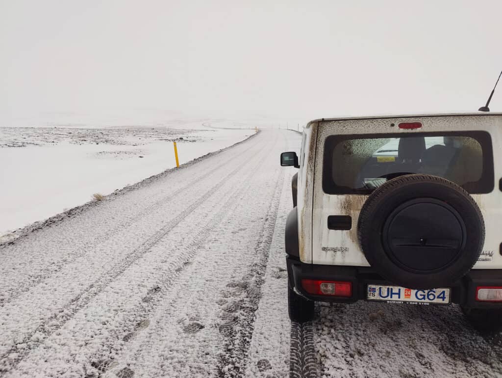 Suzuki Jimny rental car on a snow-dusted gravel road in Iceland in October — photographed by Marcel Strobel
