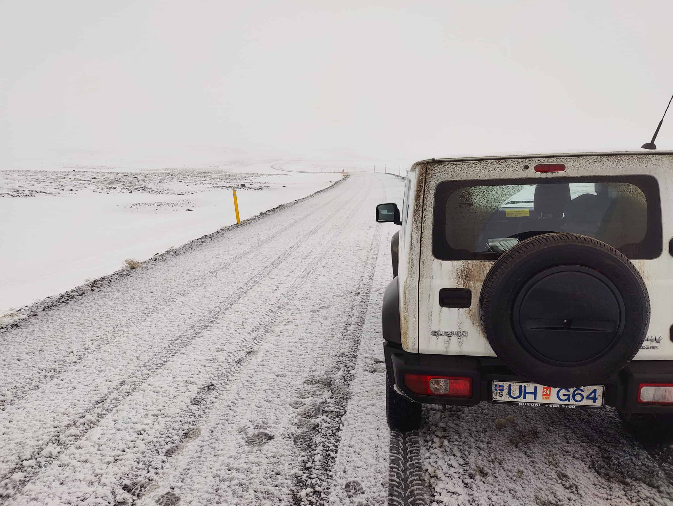 Suzuki Jimny rental car on a snow-dusted gravel road in Iceland in October — photographed by Marcel Strobel